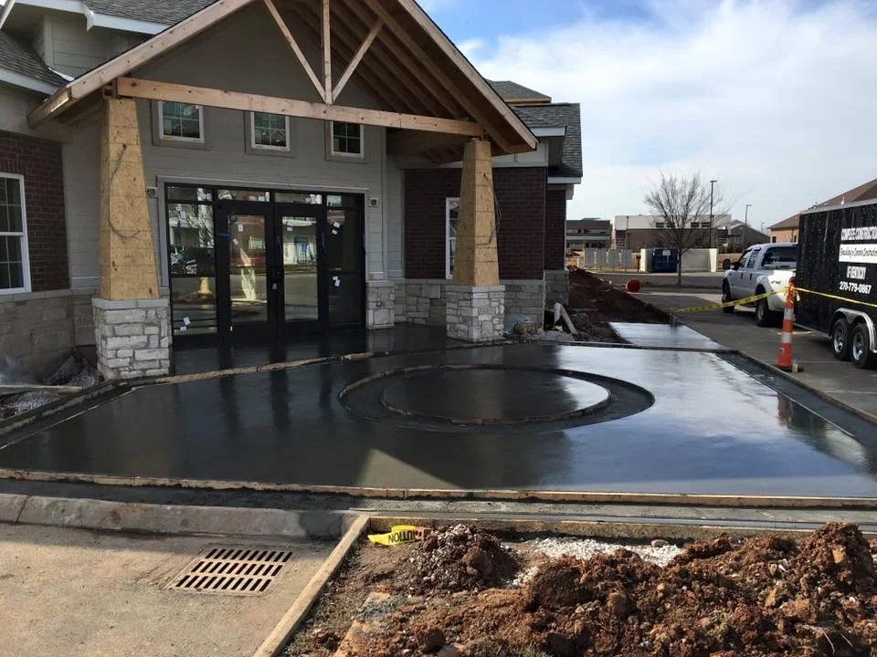Finished concrete driveway with circular decorative inlay pattern at residential entrance