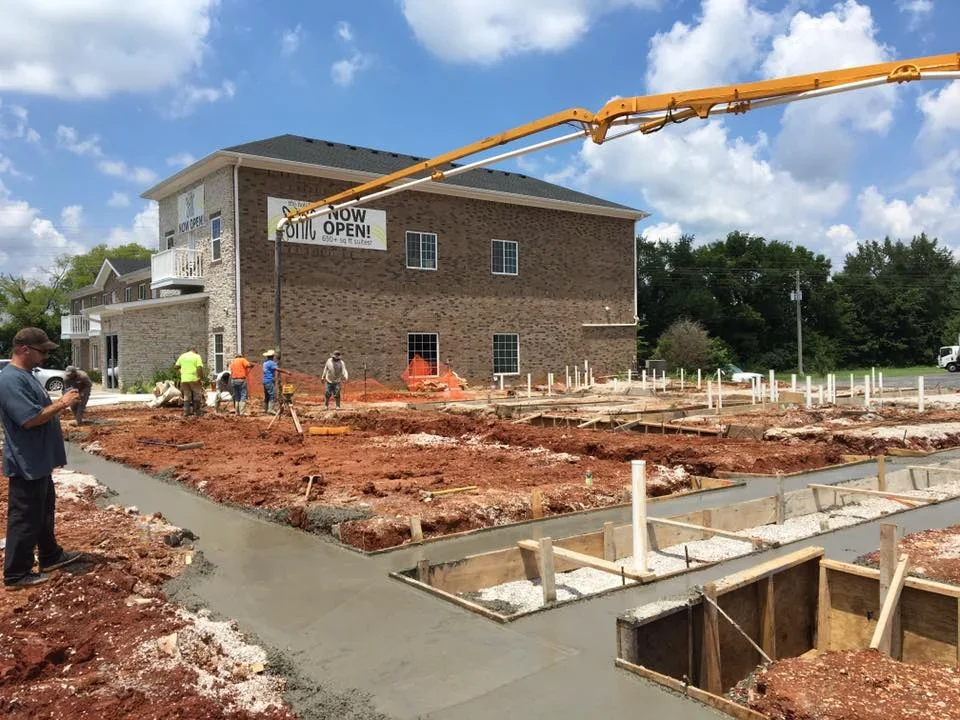 Concrete foundation work with freshly poured footings and wooden forms on commercial building site