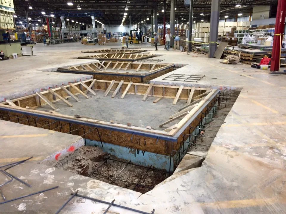 Commercial concrete foundation pour with wooden framing and rebar in warehouse setting